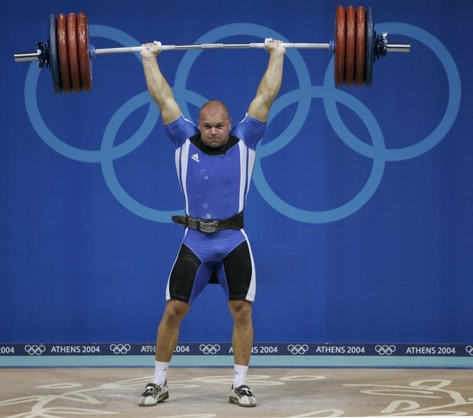 © Reuters. Bulgaria's Milen Dobrev powers a lift during the men's 94 kg weightlifting event in Athens.