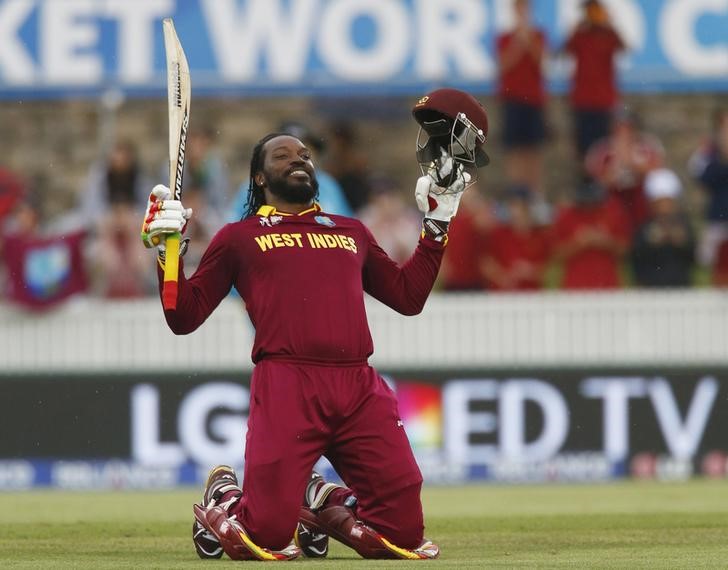 © Reuters. West Indies batsman Chris Gayle celebrates scoring 200 runs, a double century, during their World Cup Cricket match against Zimbabwe in Canberra