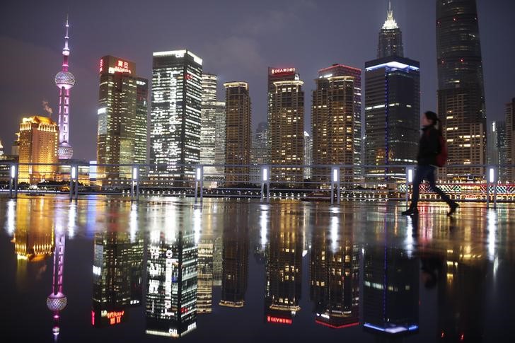 © Reuters. Woman walks at the Bund in front of the financial district of Pudong in Shanghai