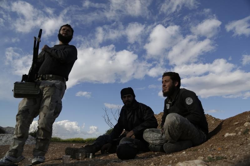 © Reuters. Rebel fighters from the Ahrar al-Sham Islamic Movement sit near Morek in the northern countryside of Hama