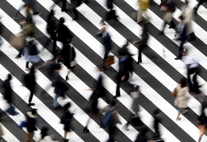 © Reuters. File photo of people crossing a street in Tokyo