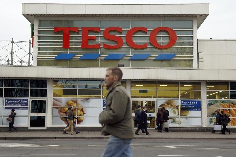 © Reuters. Pedestrians pass a Tesco supermarket in London