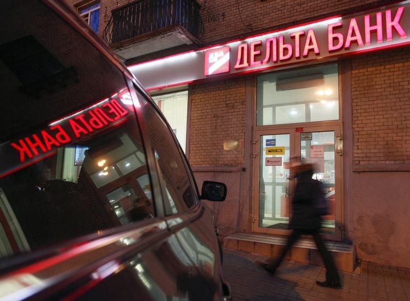 © Reuters. A man walks in a front of a branch of Delta Bank in Kiev