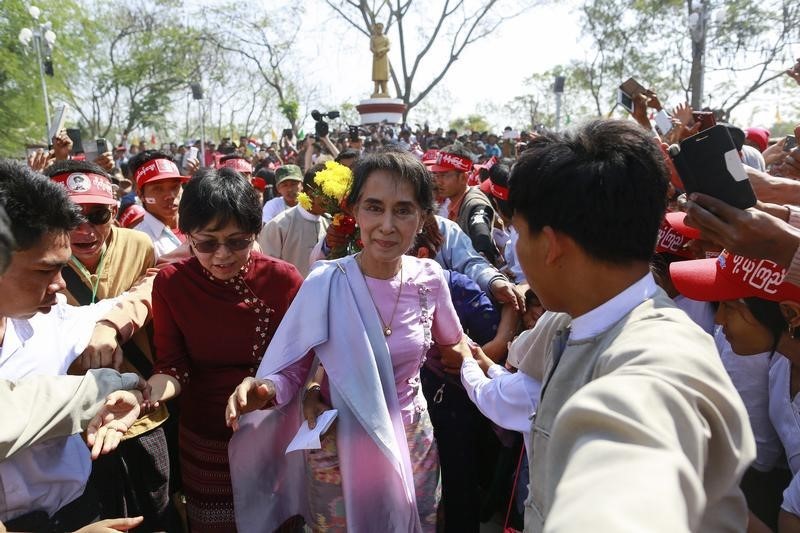 © Reuters. Myanmar's pro-democracy leader Aung San Suu Kyi greets supporters, after giving a speech in front of a statue of her father, General Aung San, to mark his 100th birthday anniversary in his hometown of Natmau