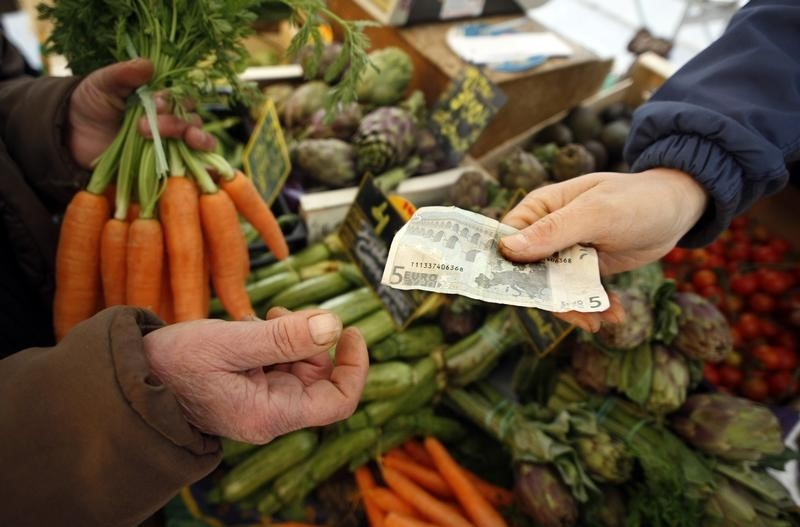 © Reuters. A shopper buys vegetables on a market in Nice