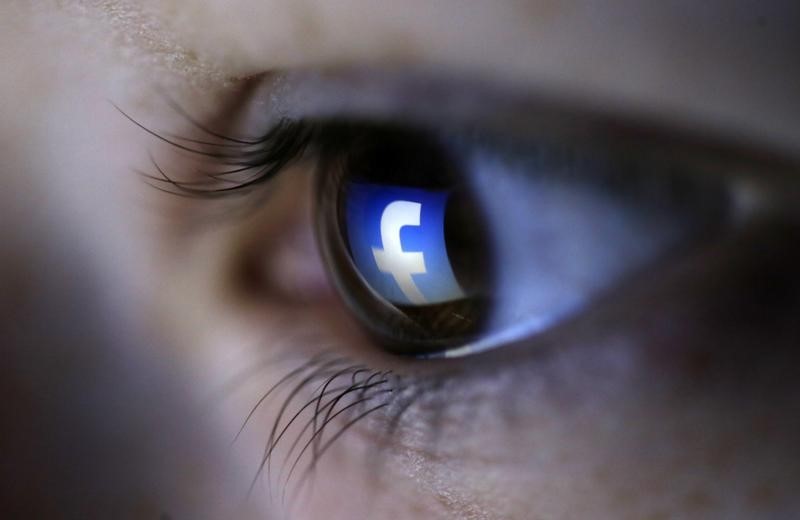 © Reuters. A picture illustration shows a Facebook logo reflected in a person's eye, in Zenica