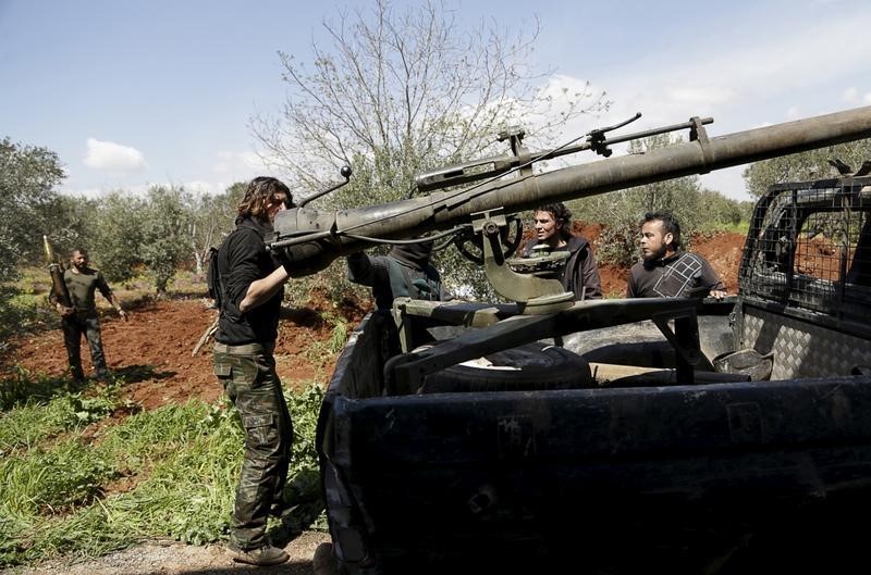 © Reuters. Rebel fighters prepare their weapons before heading to the frontline of Idlib city in northern Syria