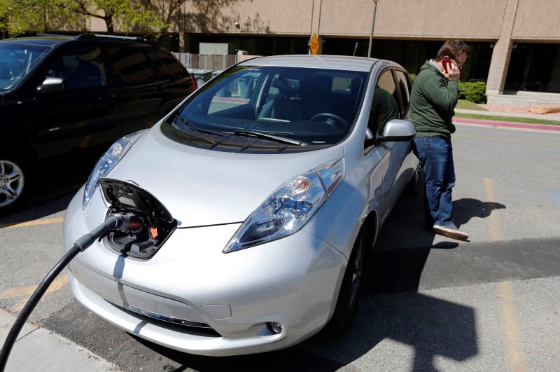 © Reuters. File photo of Miller making a phone call as he charges his 2013 Nissan Leaf electric car at ABB Inc.'s DC fast charging station in Salt Lake City