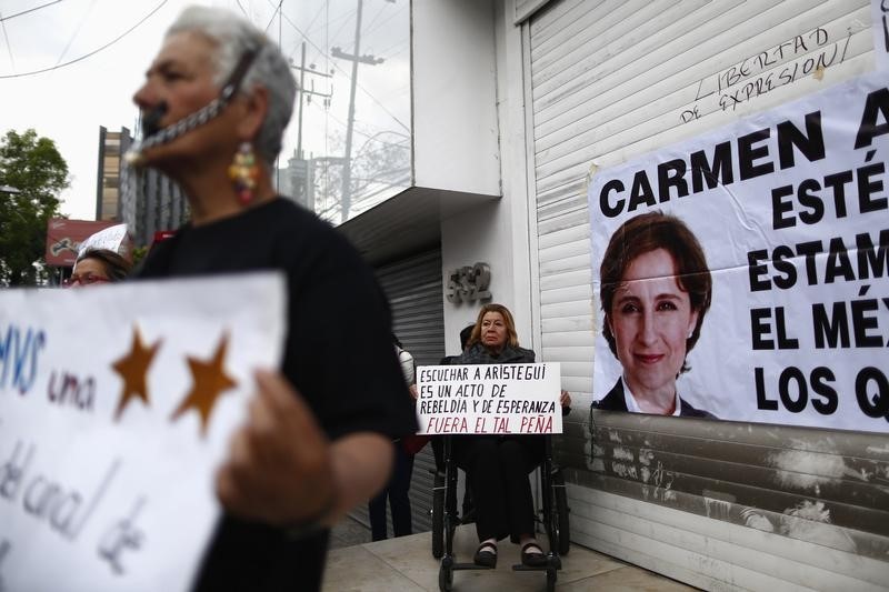 © Reuters. A supporter holds a sign during a protest against the dismissal of Mexican journalist Carmen Aristegui, outside MVS Radio's station building in Mexico City