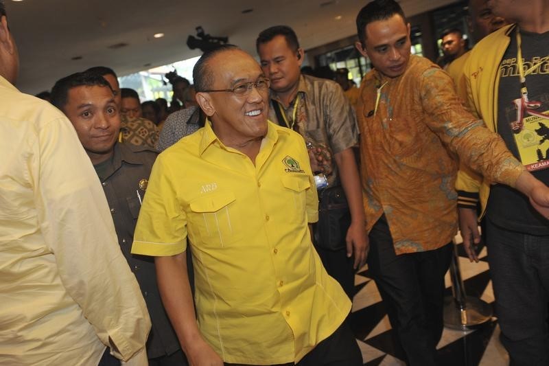 © Reuters. Aburizal Bakrie (C), the head of Golkar Party walks as he enters a plenary session at the Golkar Party National Conference in Nusa Dua, on the  Indonesian resort island of Bali