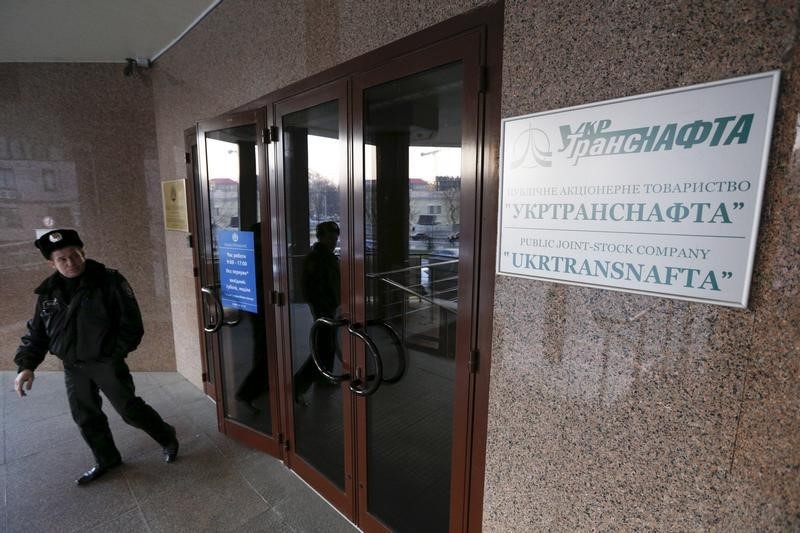 © Reuters. Policeman stands next to an entrance to the head office of Public Joint-Stock Company UkrTransNafta in Kiev