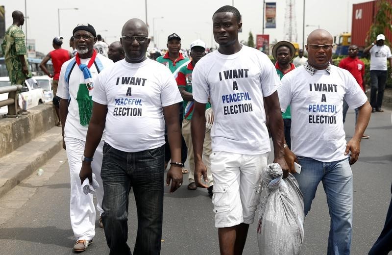 © Reuters. Men wear t-shirts about a peaceful election during a street procession 'March for Change' in Lagos