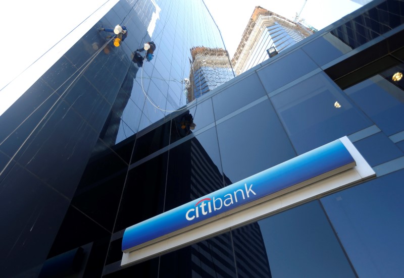 © Reuters. Window washers work above a logo of Citibank in downtown Buenos Aires