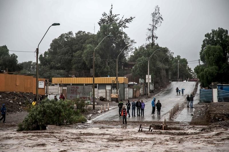 © Reuters. Locals gather near a flooded road after heavy rains in Copiapo city