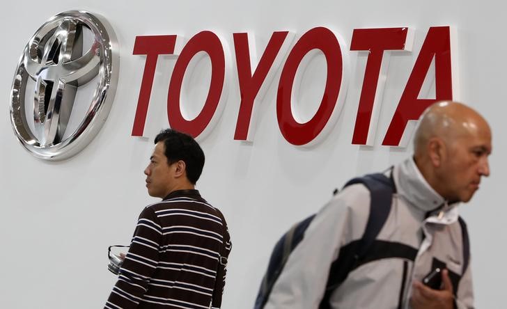© Reuters. Visitors walks under a logo of Toyota Motor Corp at the company's showroom in Tokyo
