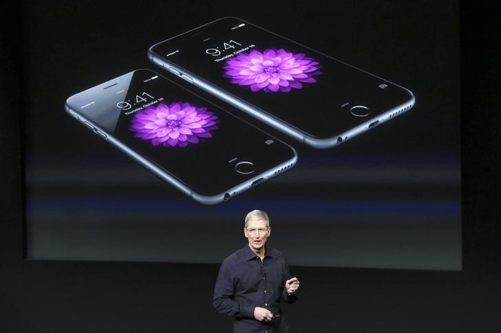 © Reuters. Apple CEO Tim Cook stands in front of a screen displaying the IPhone 6 during a presentation at Apple headquarters in Cupertino