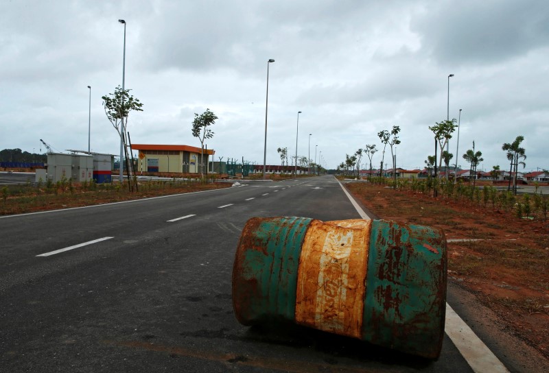 © Reuters. Barile di petrolio arrugginito abbandonato per strada in Malesia.
