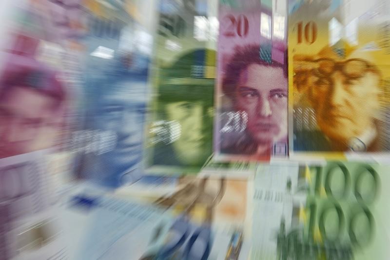 © Reuters. Various Euro banknotes lay next to various Swiss Franc notes in this picture illustration at a bank in Warsaw