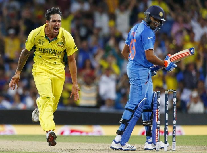 © Reuters. Australian bowler Mitchell Johnson (L) reacts after bowling out India's Rohit Sharma (R) during their Cricket World Cup semi-final match in Sydney