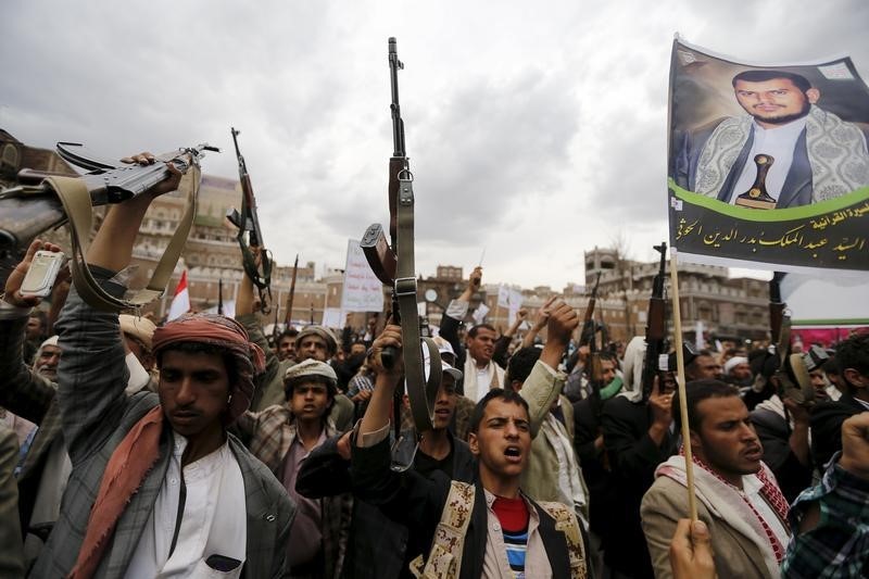 © Reuters. Rebeldes xiitas empunham armas durante manifestação contra ataques aéreos em Sanaa