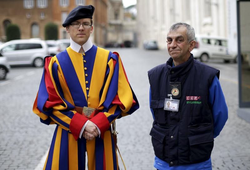 © Reuters. Roberto, a homeless man who lives around Vatican, poses with a Swiss guard before entering the Vatican 