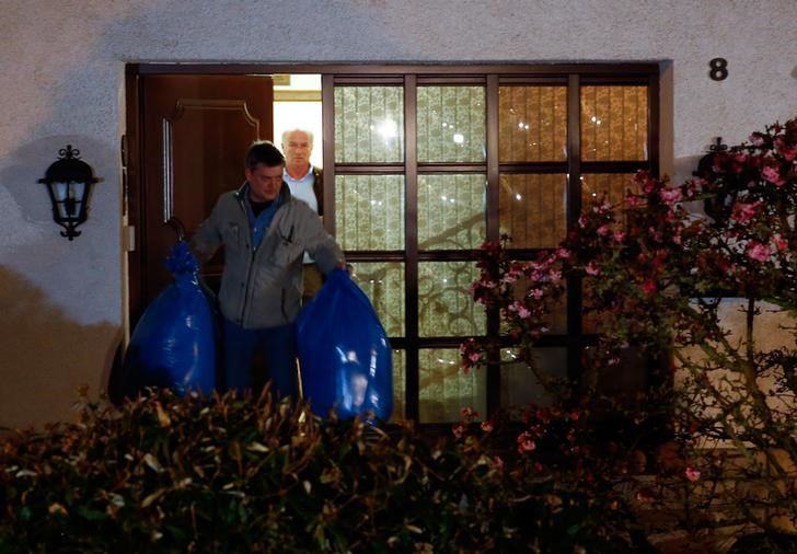 © Reuters. Policiais alemães saem com sacolas de casa que pertenceria a pais de copiloto em Montabaur