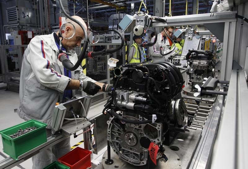 © Reuters. Employees of French carmaker PSA Peugeot Citroen work on the new engine "EB" assembly line at the company engines factory in Tremery near Metz