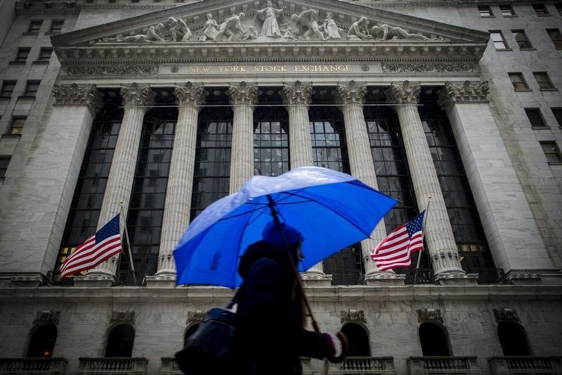 © Reuters. A morning commuter carries an umbrella as she passes by the NYSE during a winter storm in New York