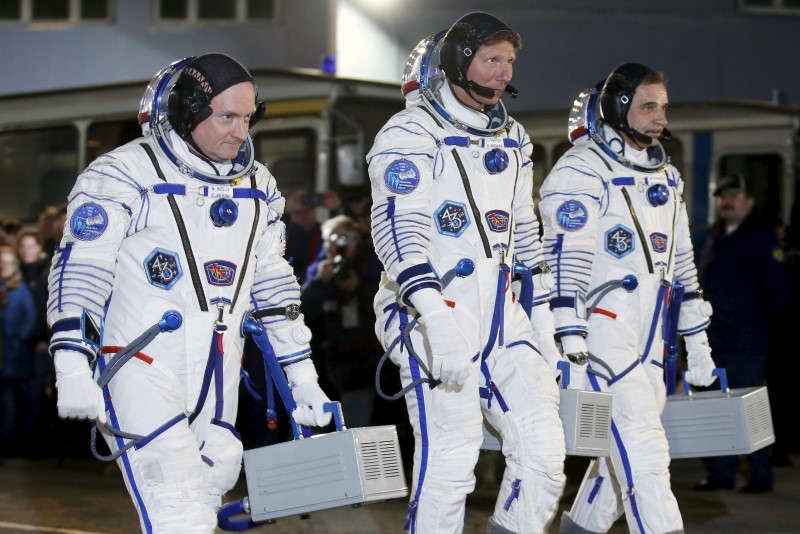 © Reuters. ISS crew of Kelly of the U.S. and  Kornienko and Padalka of Russia walk after donning space suits at the Baikonur cosmodrome 