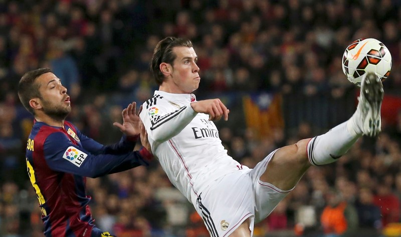 © Reuters. Barcelona's Alba challenges Real Madrid's Bale during their Spanish first division "Clasico" soccer match at Camp Nou stadium in Barcelona