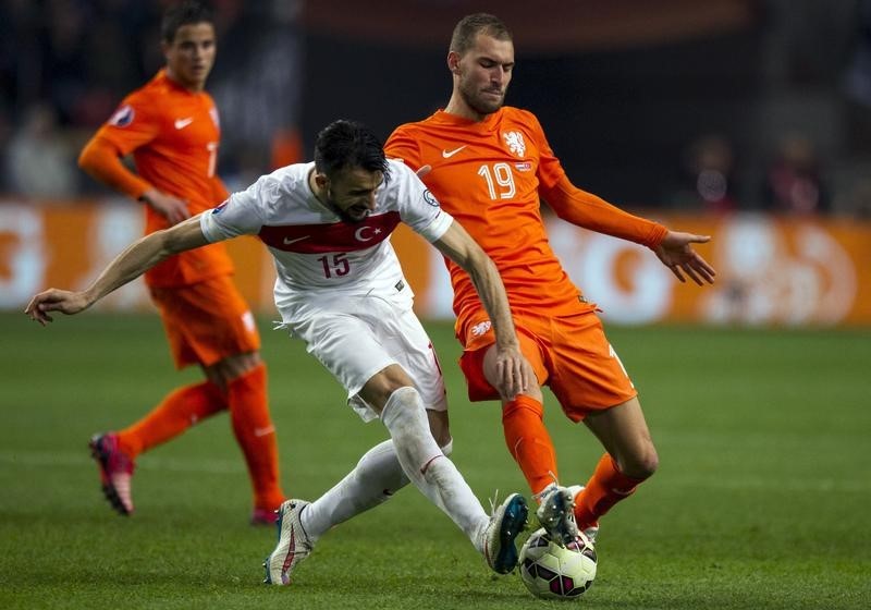 © Reuters. Netherlands' Bas Dost fights for the ball with Turkey's Mehmet Topal during their Euro 2016 qualifying soccer match in Amsterdam