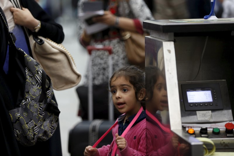 © Reuters. Girl waits with her family for their flight at the Sanaa Airport