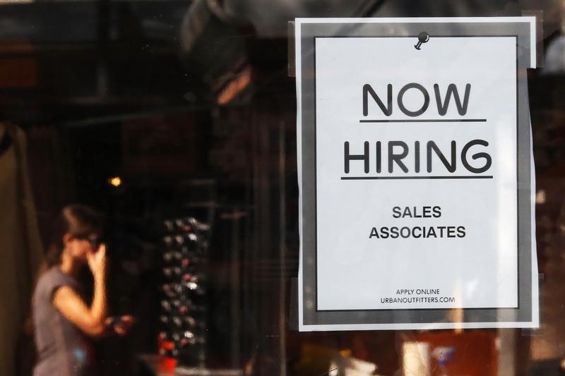 © Reuters. A "Now Hiring" sign hangs on the door to the Urban Outfitters store at Quincy Market in Boston