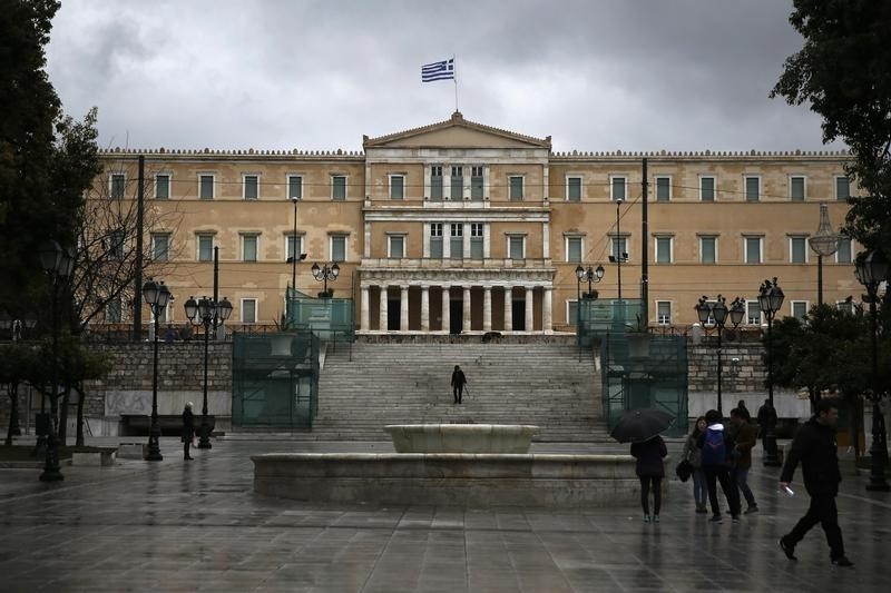 © Reuters. A Greek national flag flutters atop the parliament building as people make their way on main Syntagma square