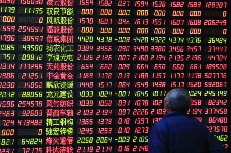© Reuters. An investor looks on in front of an electronic board showing stock information at a brokerage house in Shanghai