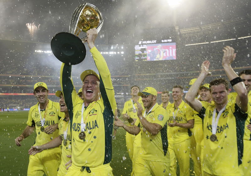 © Reuters. Australia's wicket keeper Haddin holds aloft the Cricket World Cup trophy alongside team mates after they defeated New Zealand in the final match at the Melbourne Cricket Ground
