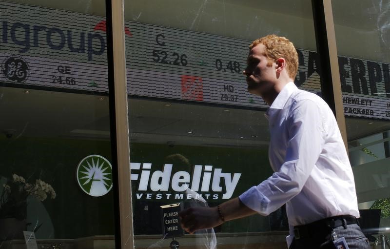 © Reuters. A pedestrian walks past a stock ticker at a Fidelity Investments office in Boston