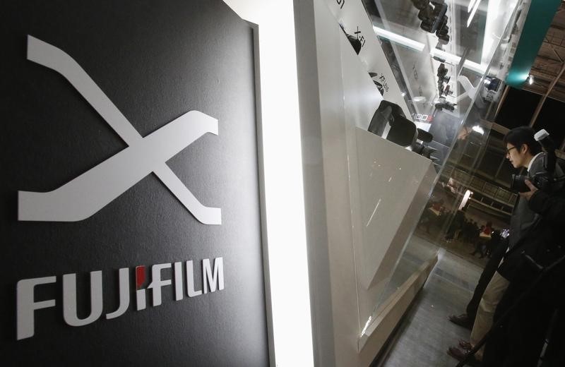 © Reuters. A visitor looks at Fujifilm's digital cameras at the Camera & Photo Imaging Show 2013 in Yokohama