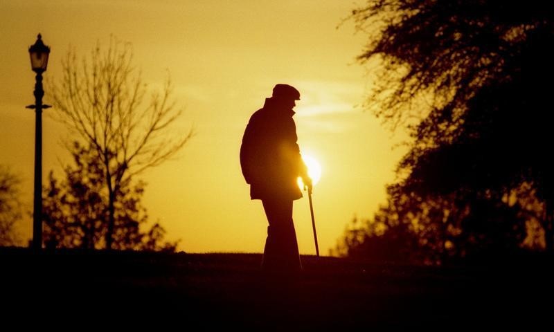 © Reuters. A MAN STROLLS THROUGH A PARK AT SUNSET IN LONDON