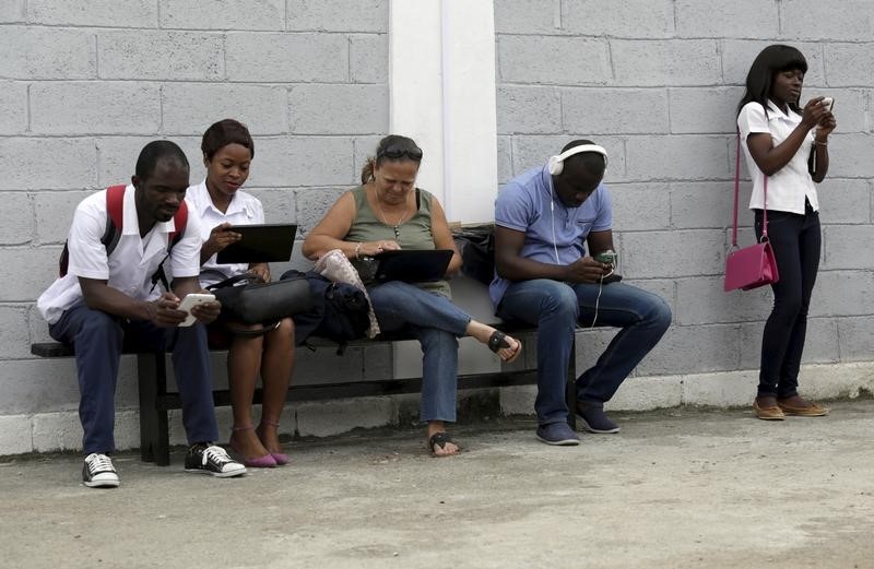 © Reuters. Young people use internet by wifi free at the studio of Cuban artist Alexis Leyva "Kcho" in Havana 