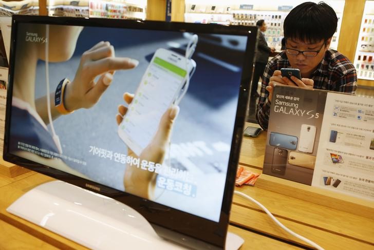 © Reuters. A man tries out Samsung Electronics' new Galaxy S5 smartphone at the company's headquarters in Seoul