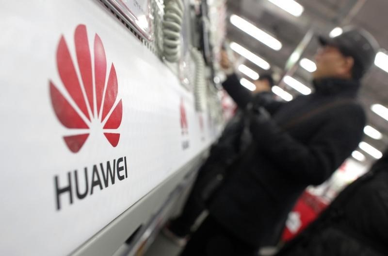 © Reuters. A man looks at a Huawei mobile phone as he shops at an electronic market in Shanghai