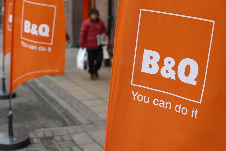 © Reuters. A woman walks past a flag outside a B&Q Warehouse hardware shop in London