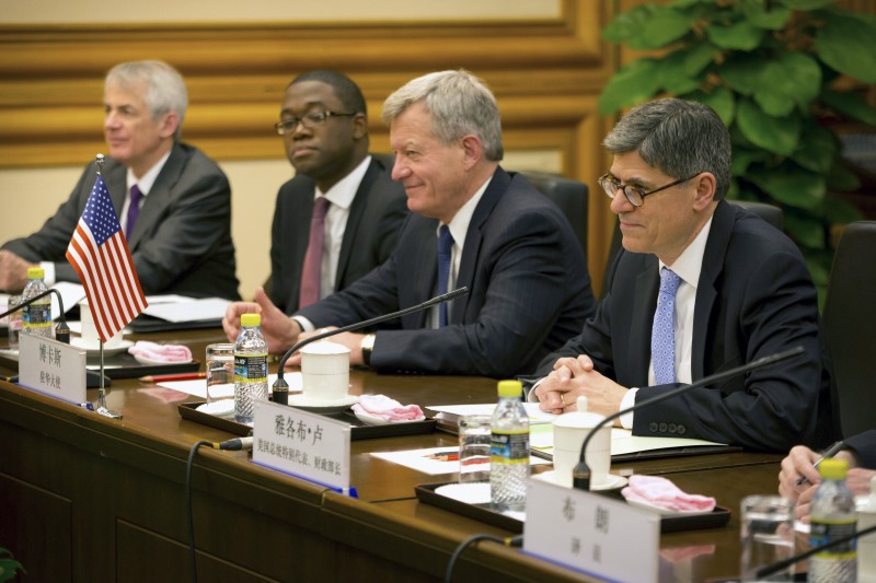 © Reuters. Lew and Baucus attend a meeting in Beijing