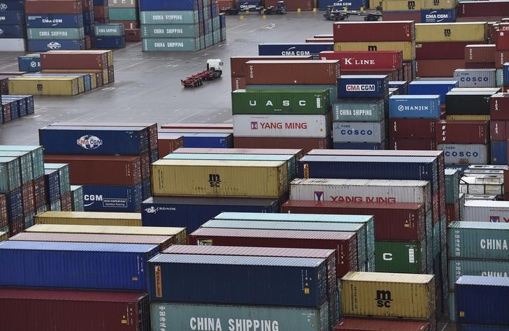 © Reuters. A transporter lorry drives between shipping containers stacked at the port of Felixstowe in south east England