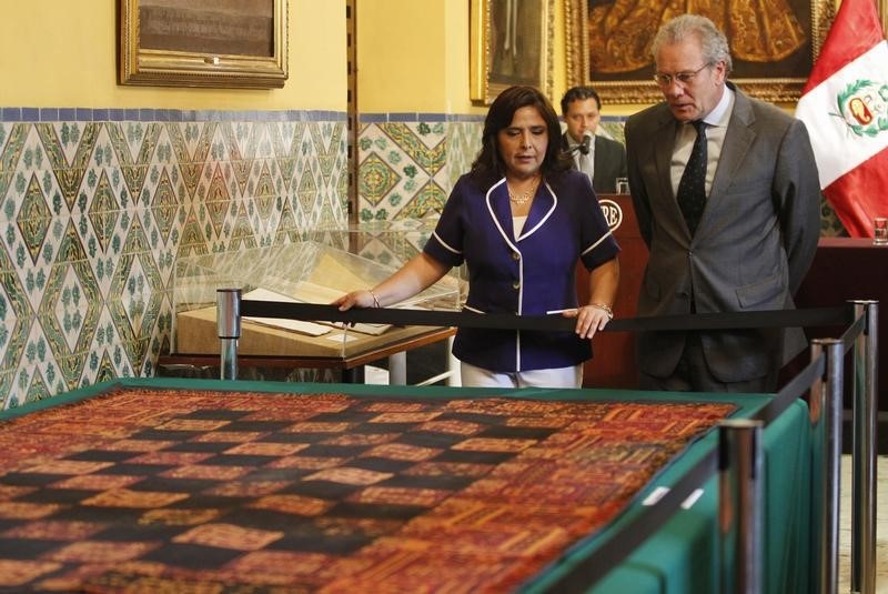 © Reuters. Peru's Prime Minister Ana Jara and Foreign Minister Gonzalo Gutierrez  look at a recovered textile from Paracas pre-hispanic period at the Foreign Ministry in Lima