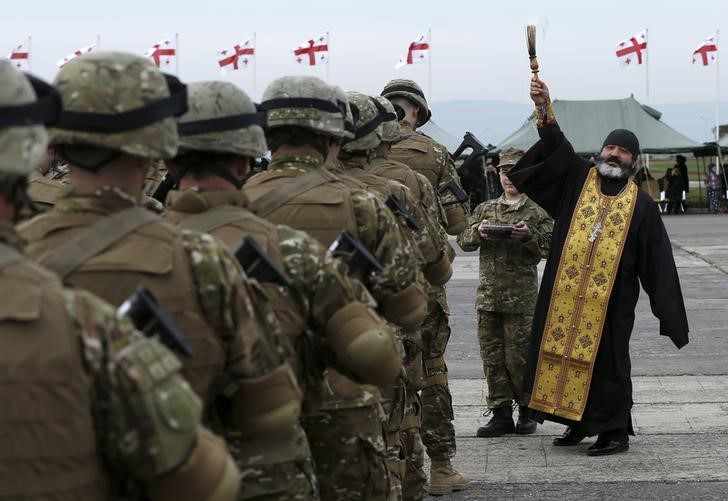 © Reuters.  Священник на проводах военнослужащих грузиснкой армии в Афганистан на базе в Вазиани