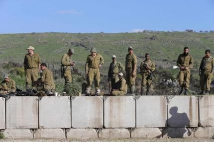 © Reuters. Israeli soldiers stand on concrete blocks near the border with Lebanon