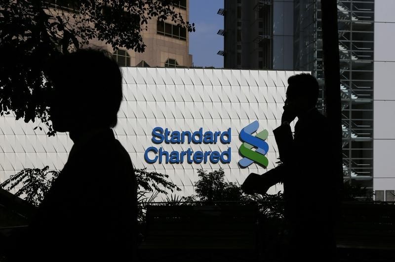 © Reuters. People walk past the main branch of Standard Chartered in Hong Kong
