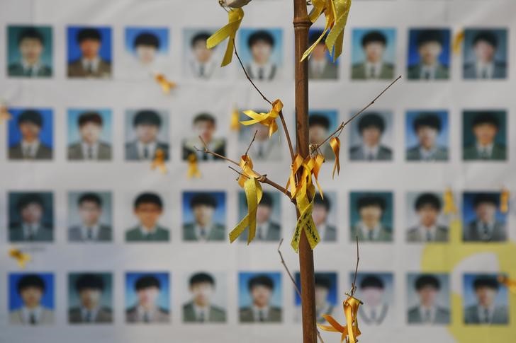 © Reuters. Portraits of students who died in the Sewol ferry disaster are seen behind an art installation dedicated to the victims in central Seoul